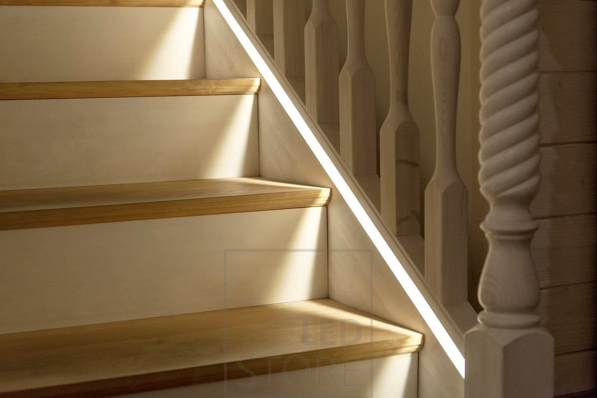 Led ribbon in a profile milled into the stair railing as close as possible to the steps.